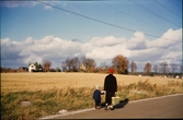 Gamla Norrvägen, Växjö 1956. Lyckans höjd. En kvinna och ett barn promenerar längs vägen.