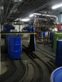 Industrilokal med transportanordning för tunnor i golvet. Interiörfotografi från byggnad vid Soabs industrianläggning i Mölndals Kvarnby, år 2007. Anläggningen användes vid fototillfället av Hexion Speciality Chemicals Sweden AB.