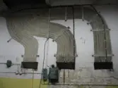 Vägg där ett flertal ledningar en gång suttit. Interiörfotografi från byggnad vid Soabs industrianläggning i Mölndals Kvarnby, år 2007. Anläggningen användes vid fototillfället av Hexion Speciality Chemicals Sweden AB.