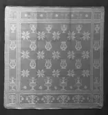 Servett i linnedamast med mönster hämtat ur Afhandling om drällers och dubbla golfmattors tillverkning, med begagnande af harnesk-rustning / författad af J.E. Ekenmark och systrar, Stockholm, 1928. Johan Erik (1786-1833), Hedda Christina ( 1786-1833), Lovisa Maria (1795-) och Gustava Fredrika, gift Beckvall (1800-). Invävt IIWL, kommer från Ångermanland.