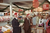 Kjell och Thore har på sig julmössor och delar ut julklappar till kunderna, Domus vid Nya torget 1968.
Relaterade motiv: 2024_1184 - 1263.
