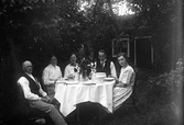 Familjen Karlsson vid middagsbordet i trädgården i Karlstorp, 1930-tal
