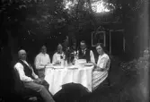 Familjen Karlsson vid middagsbordet i trädgården i Karlstorp, 1930-tal