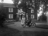 Linus med hustru Anna Karlsson samt motorcykel framför hemmet Karlstorp, 1930-tal