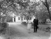 Lilly och Sven poserar vid uppfarten till sitt hus i Lysinge Stora Mellösa, 1930-tal