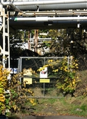 Ett flertal rörledningar samt en grind vid Soabs industrianläggning i Mölndals Kvarnby, år 2007. Anläggningen användes vid fototillfället av Hexion Speciality Chemicals Sweden AB.