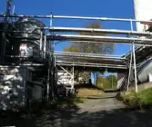 Äldre stenbelagd väg intill byggnader vid Soabs industrianläggning i Mölndals Kvarnby, år 2007. Över vägen löper en mängd rörledningar. Anläggningen användes vid fototillfället av Hexion Speciality Chemicals Sweden AB.