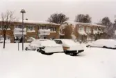 Snödrivor vid bostadshusen på Höjdgatan i Stensjöbacke, Mölndal, efter snöstormen den 17 november 1995. I förgrunden bilar på en parkeringsplats.