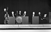 Okänd orkester, en sextett, på Stadshotellets scen i Varberg. Blåsarna sitter bakom pulpeter med trumslagaren bakom, kontrabasisten till vänster och pianisten till höger. (Se även bild nr GB2_4011)