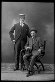 Två män med käpp och hatt