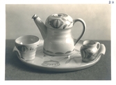 Tekanna med en liten mugg, liten mjölk-/gräddkanna samt tillhörande serveringsbricka från Bo Fajans, formgivare Allan Ebeling tidigt 1900-tal.