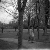 Kvinna promenerar i en park.