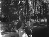 Mor med barn i famnen.