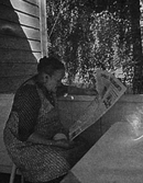 En äldre kvinna som läser Västmanlands Läns Tidning.