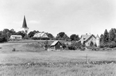 Vy över en del av Rävemåla med Älmeboda kyrka i bakgrunden. 
Nuvarande kyrkan i Älmeboda uppfördes åren 1876-1877 i historiserande blandstil, efter ritningar av arkitekt Abraham Ludvig Hedin. 
Kyrkan har en nord-sydlig orientering med kor i söder och en vidbyggd sakristia söder om koret. Kyrktornet med huvudingång ligger i norr. Tornet är försett med romanska ljudöppningar, tornur och hög nygotisk spira.