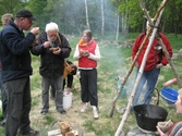 Besökare som deltar vid invigningen av Fagereds natur- och kulturstig i Lindome år 2008. Museitekniker Sven-Åke Svensson, klädd i röd jacka och blåjeans, står och bevakar elden där en stor järngryta hänger i en träställning ovanför. På flera ställen står spänner med vatten. Personer i närheten äter ur små skålar och längst ner ses handgjorda dryckeskärl av trä. 
Fagered bjuder på kommunens bäst bevarade järnåldersmiljö. Här finns rester av en gammal hålväg, spår av äldre jordbruksmark och ett 40-tal gravar. 
Relaterade motiv: 2024_1300 - 1308.