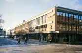 Kungsgatan, Växjö, kvarteret Unaman med SE-banken (korsningen Kungsgatan/Storgatan). I bakgrunden skymtar järnvägsstationen.
Färgfoto, ca 1973.
