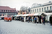 Marknad på Stortorget, Växjö. Till höger syns residenset och mitt fram några av byggnaderna längs Kungsgatan.
Färgfoto ca 1960.