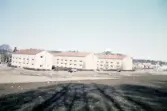 Hyreshusen på Thomas Johannisgatan, Växjö från sydost. I bakgrunden skymtar Hovsberg med det nya vattentornet.
Färgfoto ca 1960.