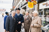 Storgatan, Växjö. Nils Hyltén-Cavallius pratar med några andra herrar på trottoaren. I bakgrunden skymtar stortorget och Riksbankens hus.
Färgfoto ca 1970.