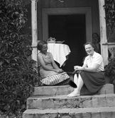 Maja och Maria tar en paus på trappen till Karlstorp, 1940-tal