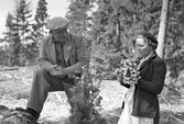 Maja Karsson och bekant plockar blommor i skogen, 1940-tal