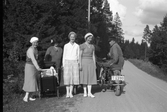 Linus Karlsson på motorcykel möter damer på grusvägen, 1940-tal