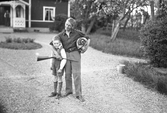 David Karlsson med pojke framför huset i Karlstorp, 1940-tal