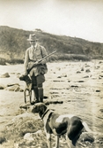 Jägare med hundar vid fors i svenska fjällen, ca 1925