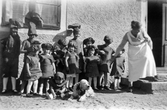 Utklädda barn med hund och vaktande kvinna på Färna herrgård, 1926