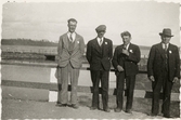 Medaljörer på bro. Vägräcke med stengardister. Stenbro i bakgrunden.