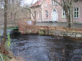 Vy västerut från Pixbovägen på gångbron Grevedämmetspången över Mölndalsfallen och Grevedämmets skola med dess västra parkering, Mölndal år 2011. Entrén till byggnaden är handikappanpassad. Ett staket sitter utmed forsens båda stensatta sidor. Dokumentation inför ombyggnation.
Relaterade motiv: 2024_1365 - 1412.