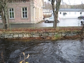 Vy österut från Pixbovägen över Mölndalsfallen samt del av Grevedämmets skola och dess södra parkering med parkerade bilar, Mölndal år 2011. Ett staket sitter utmed forsens stensatta sida. I fonden ses en komplementbyggnad som tillhör samma fastighet. Dokumentation inför ombyggnation.
Relaterade motiv: 2024_1365 - 1412.