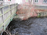 Vy från Pixbovägen på gångbron Grevedämmetspången över Mölndalsfallen och Grevedämmets skola, Mölndal år 2011. Ett staket sitter utmed forsens stensatta sida. Dokumentation inför ombyggnation.
Relaterade motiv: 2024_1365 - 1412.