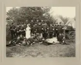 Sjukvårdspersonal vid I 11, Kronobergs hed 1908. I bakgrunden syns några av hyddorna.
Stående i främre ledet: distinktionskorpralerna Gustaf Sjögren och J A Georg Andersson, sjuksköterskan....,,
sergeant Anders Lönn, bataljonsläkare Drougge (bakom dr Drougge till höger: sjukvårdskorpral J A Carlsson (Hamneda)).
Längst till höger indelte sjukvårdssoldaten Jarl.