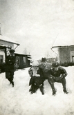 Fyra snöiga personer leker i snön vid Ulvshyttans herrgård, påsken 1915