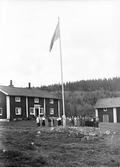 Gymnastikflickor på träningsläger samlade runt flaggstången , 1930-tal