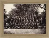 Meniga och officerare vid Kronobergs regemente har samlats för ett gruppfoto.
2:a kompaniet, trol. ca 1900-1905.
Till höger skymtar en av de berömda hyddorna.