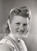 Ateljéporträtt av Aina Englund (1914 - 2012), vårdbiträde/undersköterska på Mölndals lasarett 1939 - 1941. Bilder från fotoalbum, tagna från södra sidan av Länsmansgatan vid Mölndals lasarett/sjukhus 1939 - 1941 på bland annat givarens mor Ester (född Johansson) tillsammans med kollegan/väninnan Aina Englund. De arbetade på den manliga kirurgavdelningen som vårdbiträden/undersköterskor.
Relaterade motiv: 2024_1542 - 1617.