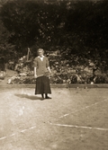 Lizzie väntar på sin motspelare på tennisbanan, 1918