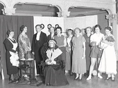 Fredrika Bremer föreningen i Varberg. Från vänster: ?, doktorinnan Ella Westerborn, lärarinnan Elin Almqvist, Maja Lundgren, Anna-Greta Sjöblom, Lalla Kumlien, Elsa Elvin, Märta Jeppsson-Nyström, Mildred Vogel, ev. Inga Reuterwall. Sittande i mitten: Flickskolans rektor Tora Lundgren. Bilden troligen tagen vid ett årsmöte och man har klätt ut sig till olika manliga och kvinnliga yrken.