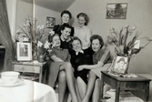 Sex kvinnor sitter eller står bredvid varandra i en personalbostad (en vindsvåning), 1939 - 1941. Sjukvårdsbiträdena (Aina, Margit och Ester) bodde i de små vindsrummen längst upp i den ursprungliga sjukhusbyggnaden på Länsmansgatan som invigdes 1924. I mitten ses Ester Johansson (1914 - 2008, gift Faldahl), vårdbiträde/undersköterska på Mölndals lasarett, som håller om två väninnor. Snett bakom henne till höger står Aina Englund (1914 - 2012). Bilder från fotoalbum, tagna från södra sidan av Länsmansgatan vid Mölndals lasarett/sjukhus 1939 - 1941 på bland annat givarens mor Ester (född Johansson) tillsammans med kollegan/väninnan Aina Englund. De arbetade på den manliga kirurgavdelningen som vårdbiträden/undersköterskor.
Relaterade motiv: 2024_1542 - 1617.