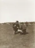 Kronobergs hed, 1901.
Laddningsövning. En man visar en annan hur man laddar ett gevär.
I bakgrunden skymtar några av byggnaderna på heden.