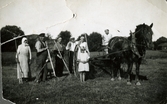 En jordbrukarfamilj bestående av fem vuxna och en flicka (troligtvis Aina Englund) står på en åker med verktyg i händerna, Hällesåker i Lindome cirka 1920. Till höger ses en förspänd arbetshäst och en kvinna som sitter på droskan. Fotot är skadat. Bilder ur fotoalbum från Aina Englund som växte upp ett bland många syskon i en jordbrukarfamilji Lindome.
Relaterade motiv: 2024_1542 - 1617.