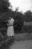 Kvinna med blommor i Karlstorp, 1950-tal