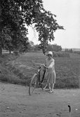 Kvinna på cykel i Karlstorp, 1940-tal