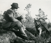 Jägare med gevär och hund på Bystad ca 1950