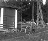 Pojke med cykelhjul hemma hos Charles Andersson, 1929