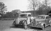 Familjefoto vid Volvo lastbil och annan bil, 1950-tal