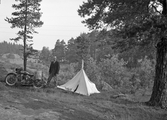 Tältande man med motorcykel, 1950-tal